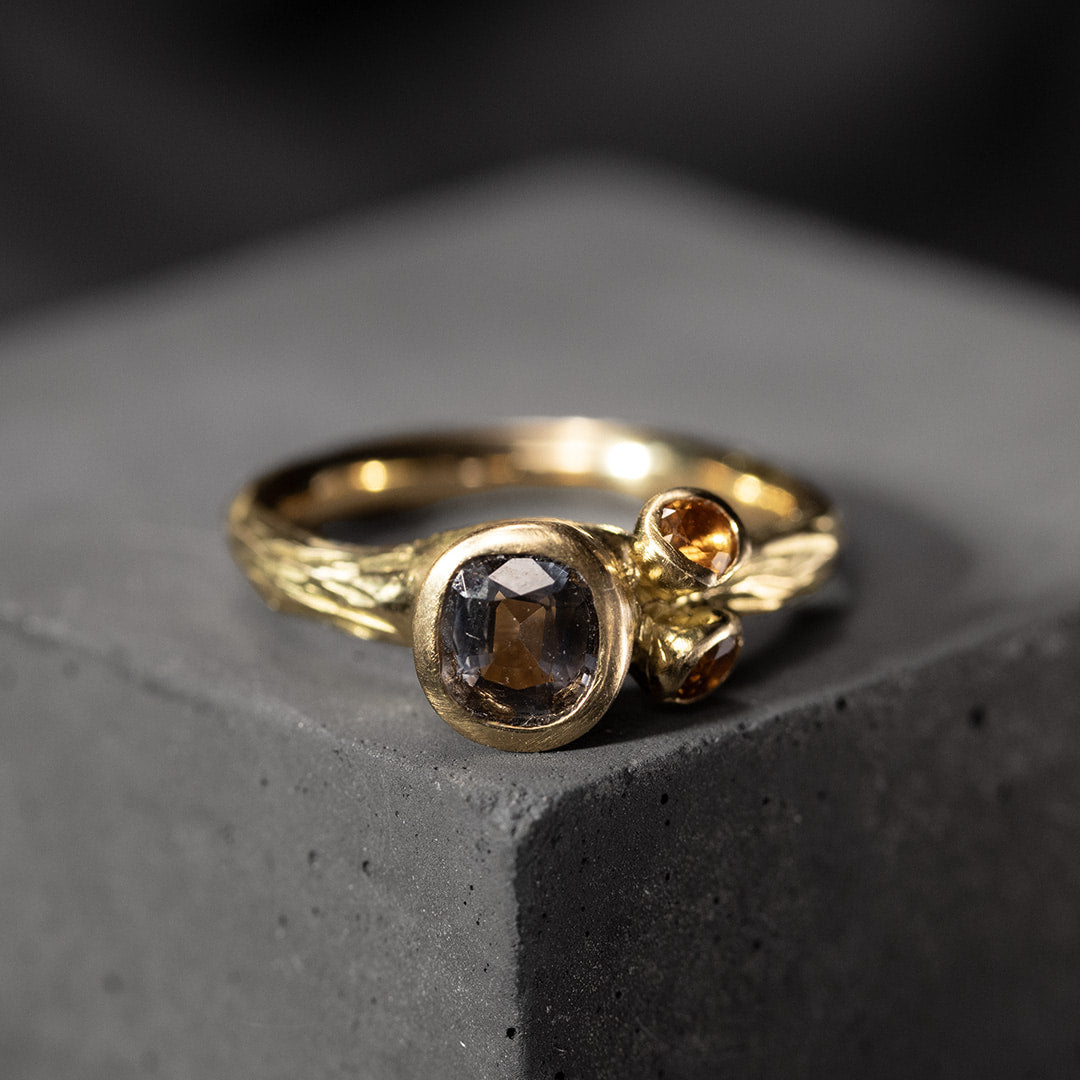 bague en or jaune avec un spinelle gris mauve et deux citrines