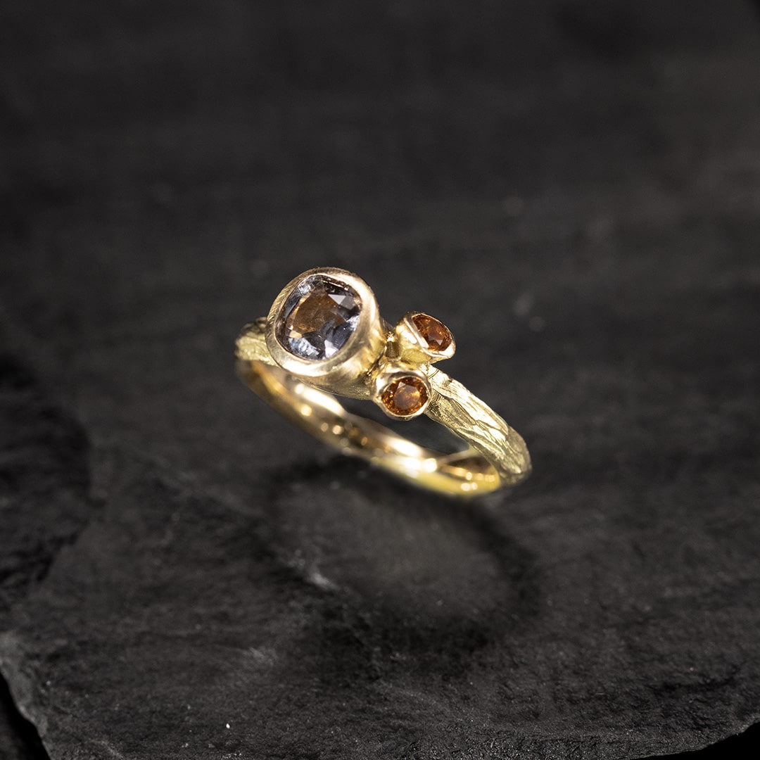 bague en or jaune avec un spinelle gris mauve et deux citrines