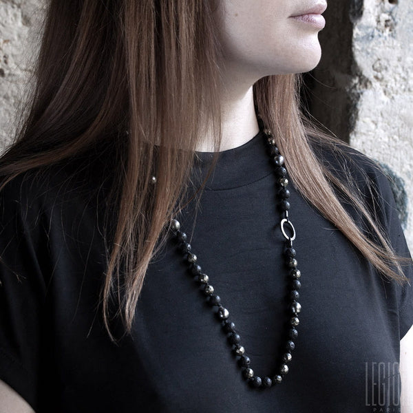 femme rousse avec un tee shirt noir portant un collier en perles noires