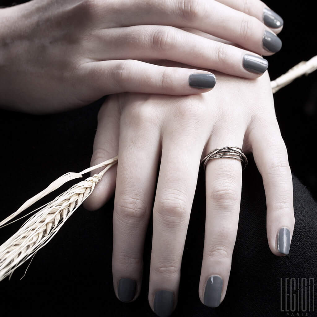 mains de femme portant une bague avec plusieurs anneaux en or blanc
