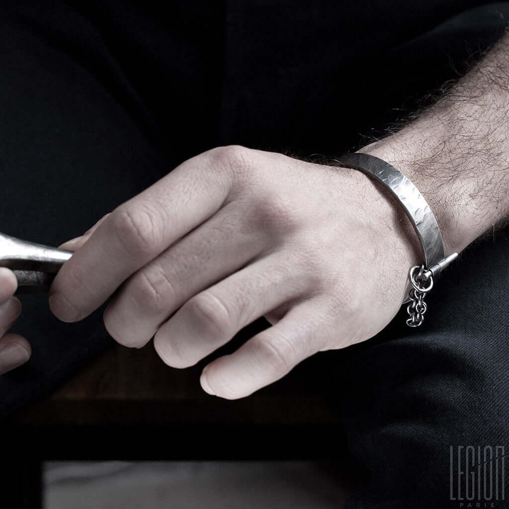 main d'homme portant un bracelet rigide en argent noir