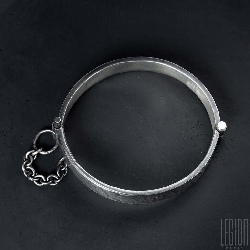 mise a plat d'un bracelet rigide en argent noir avec une goupille