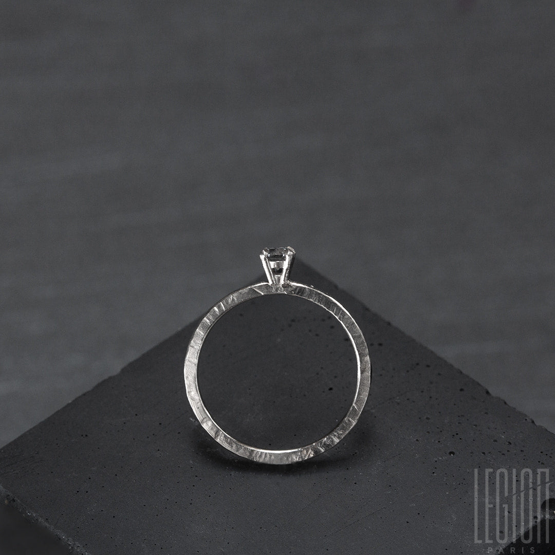 vue de côté d'un Bague solitaire en or blanc legerement martelé avec un diamant gris rond