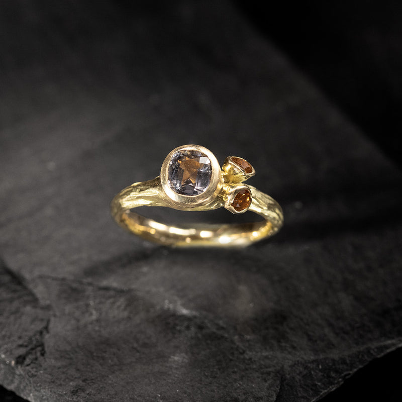 yellow gold ring with a mauve grey spinel and two citrines