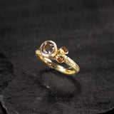 yellow gold ring with a mauve grey spinel and two citrines