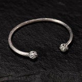 round, half-rimmed silver bracelet with pearls.