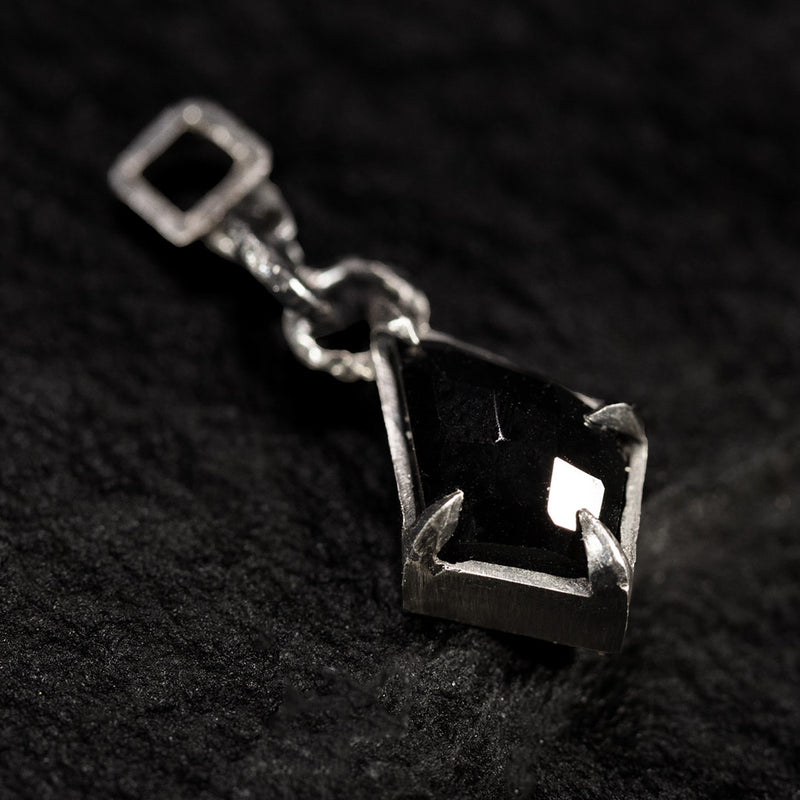 black silver earring with diamond-shaped charm featuring a black onyx in the shape of a flying deer.