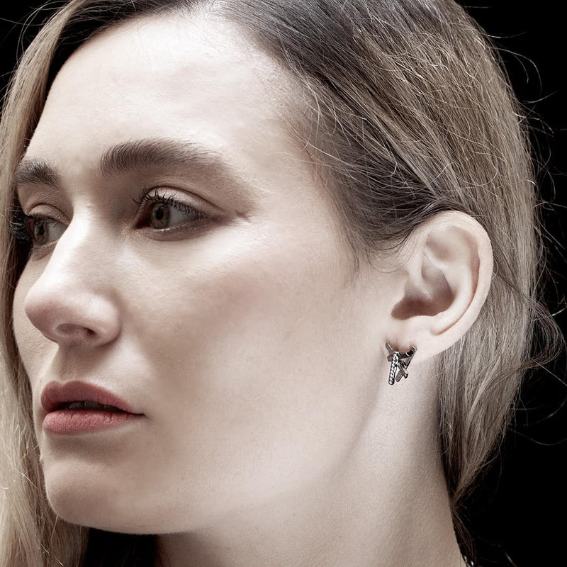 jeune femme portant une boucle d'oreille en or anthracite avec des diamants blancs