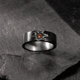 Black silver ring with a garnet in the center