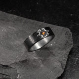 Black silver ring with a garnet in the center