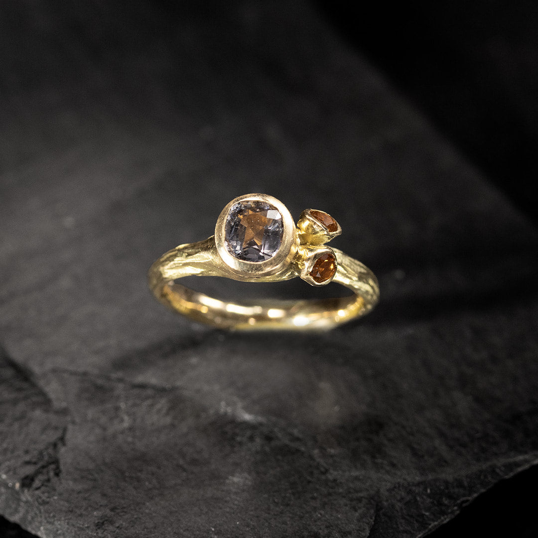 bague en or jaune avec un spinelle gris mauve et deux citrines