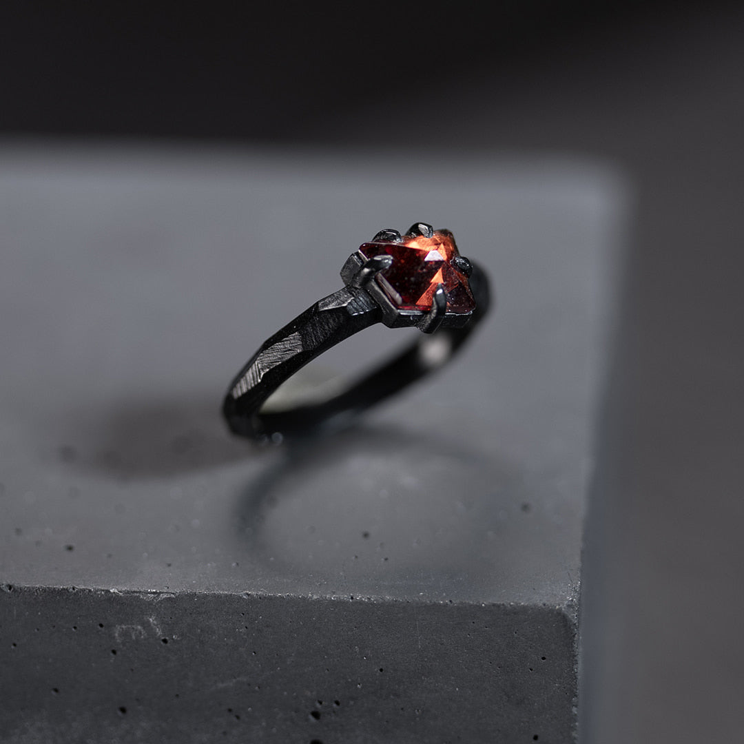 bague de fiançailles en or noir avec un grenat rouge
