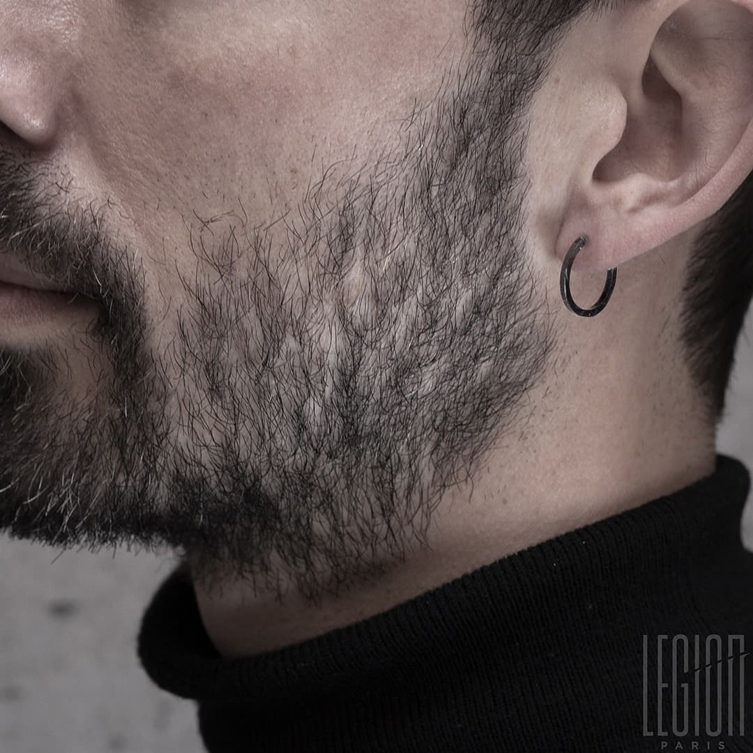 homme portant une boucle d'oreille créole en or noir