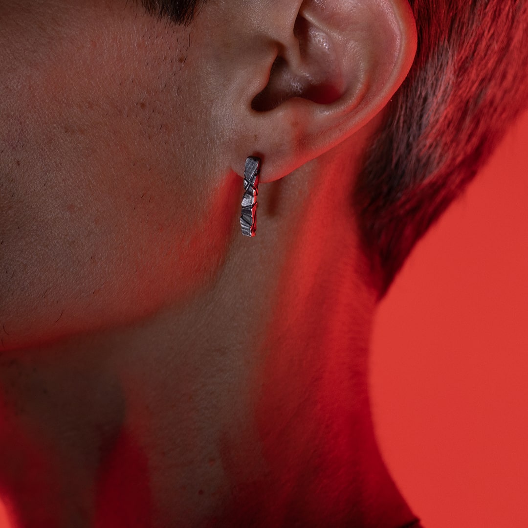 homme portant une boucle d'oreille originale texturée, brute, en argent 