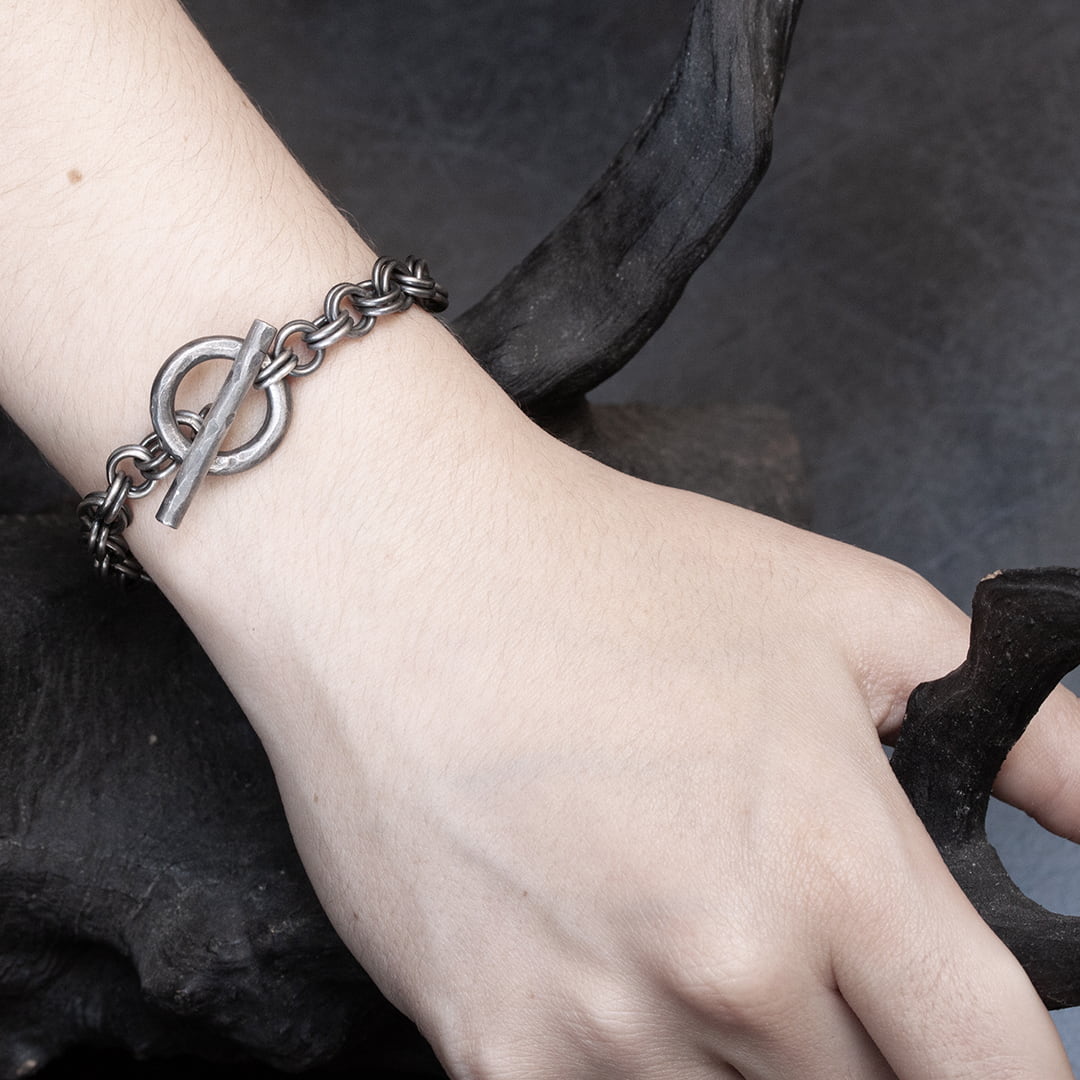 femme portant un bracelet original en argent  avec un double chaine et un fermoir anneau barrette