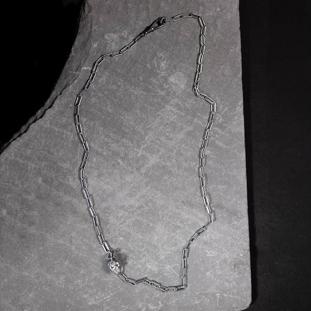 collier original en argent avec un tête de mort et deux diamants noirs