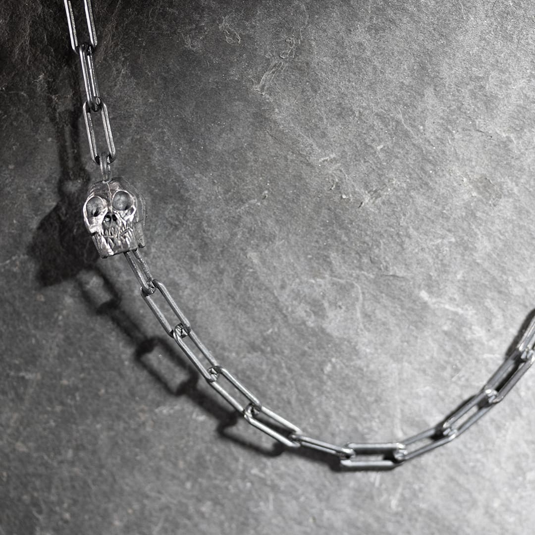 collier original en argent avec un tête de mort et deux diamants noirs