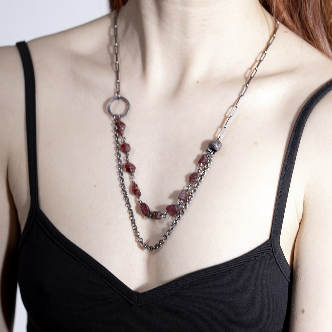 femme portant un sautoir original en argent et perles rouges