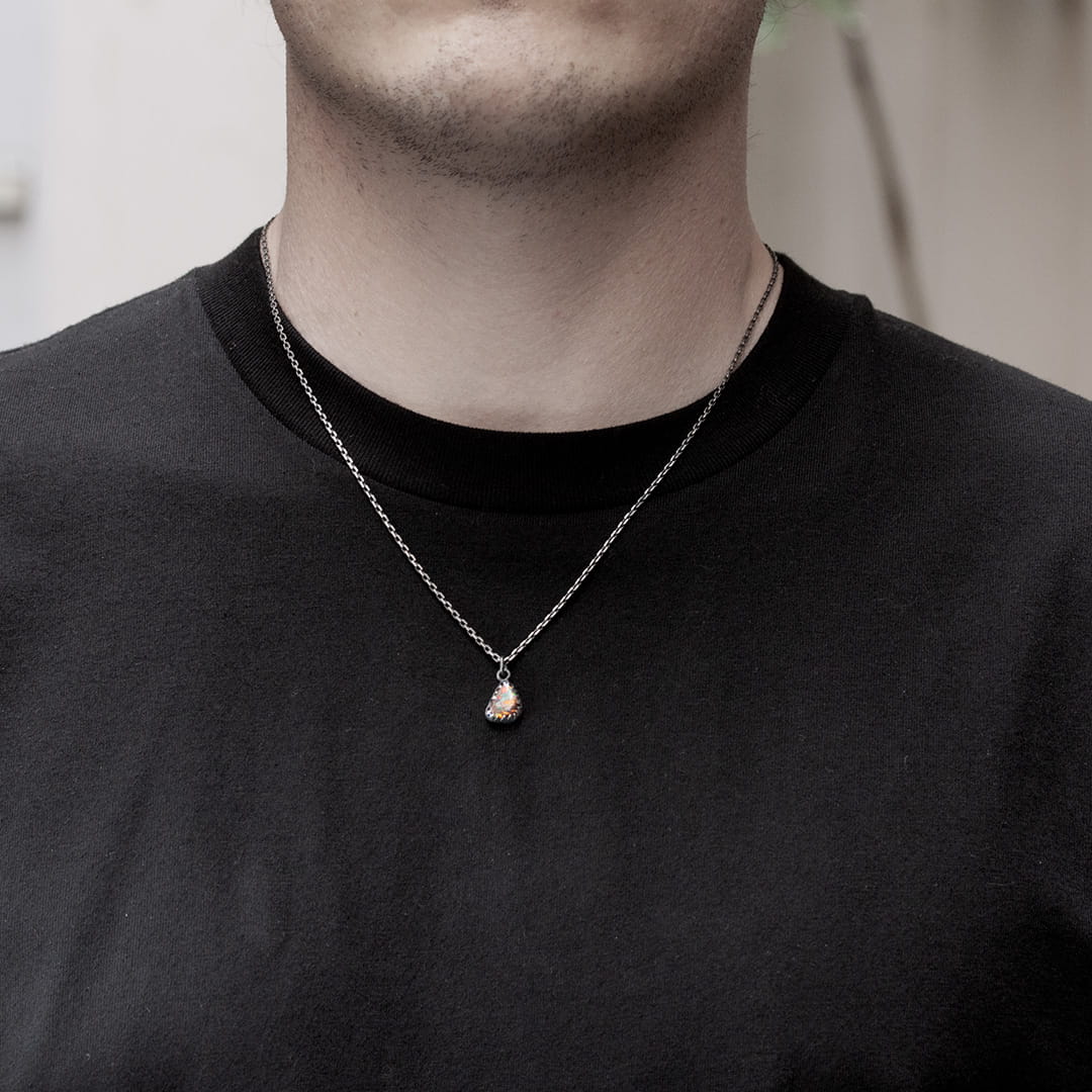 homme portant un pendentif en argent et opale brute marron