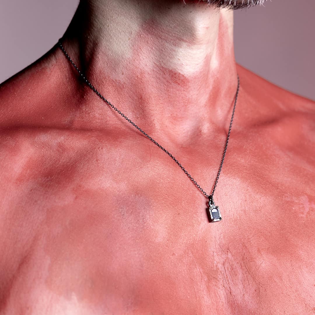 homme portant un pendentif en argent et opale brute rectangle