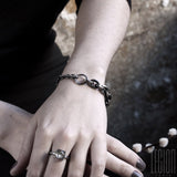main de femme portant un bracelet en chaine en argent noir