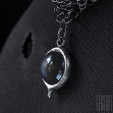 Vue de côté d'une pierre de lune grise sur un collier côte de maille en argent noir 925 Legion Paris