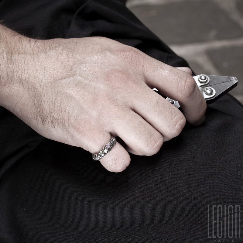 main d'homme portant un anneau en or blanc texturé au petit doigt