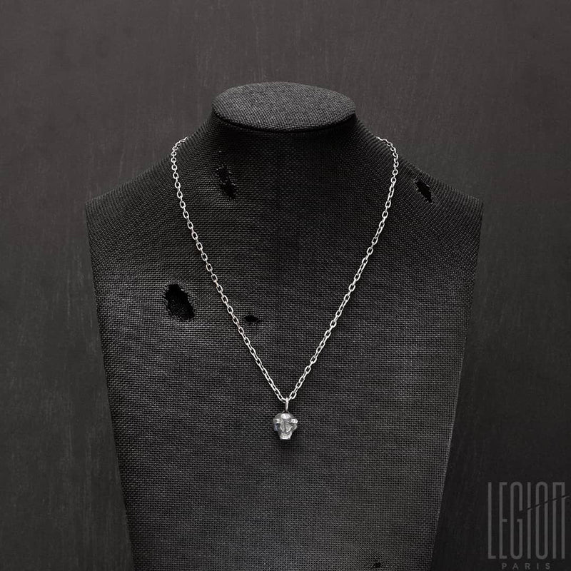 buste en tissu noir avec un pendentif en argent noir représentant une tête d'ours avec deux diamants noirs à la place des yeux sur une chaine forçat diamantée en argent noir