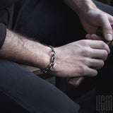 mains d'homme portant un bracelet en argent en chaine