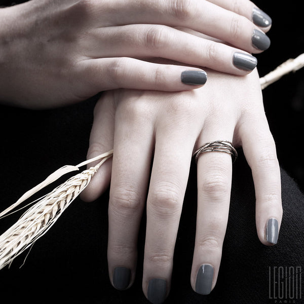 mains de femme portant une bague avec plusieurs anneaux en or blanc 