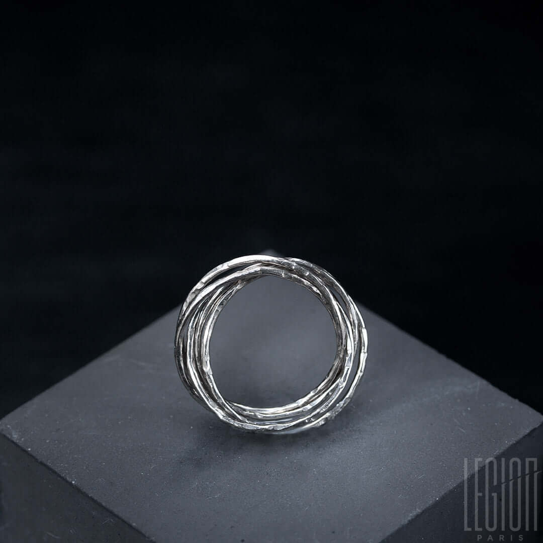 vue de côté d'une bague Legion paris en or blanc 750 avec des anneaux entrelacés et martelés