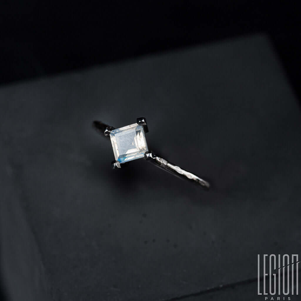 Vue de côté d'une bague en or blanc et pierre de lune carrée