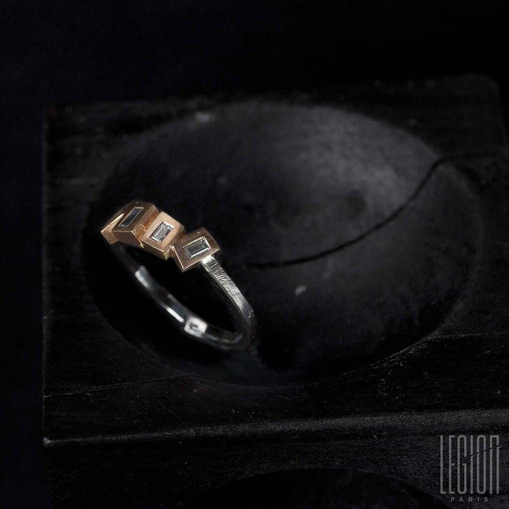 vue de côté d'une bague fine Legion paris en or rouge et or blanc et diamants sur le dessus