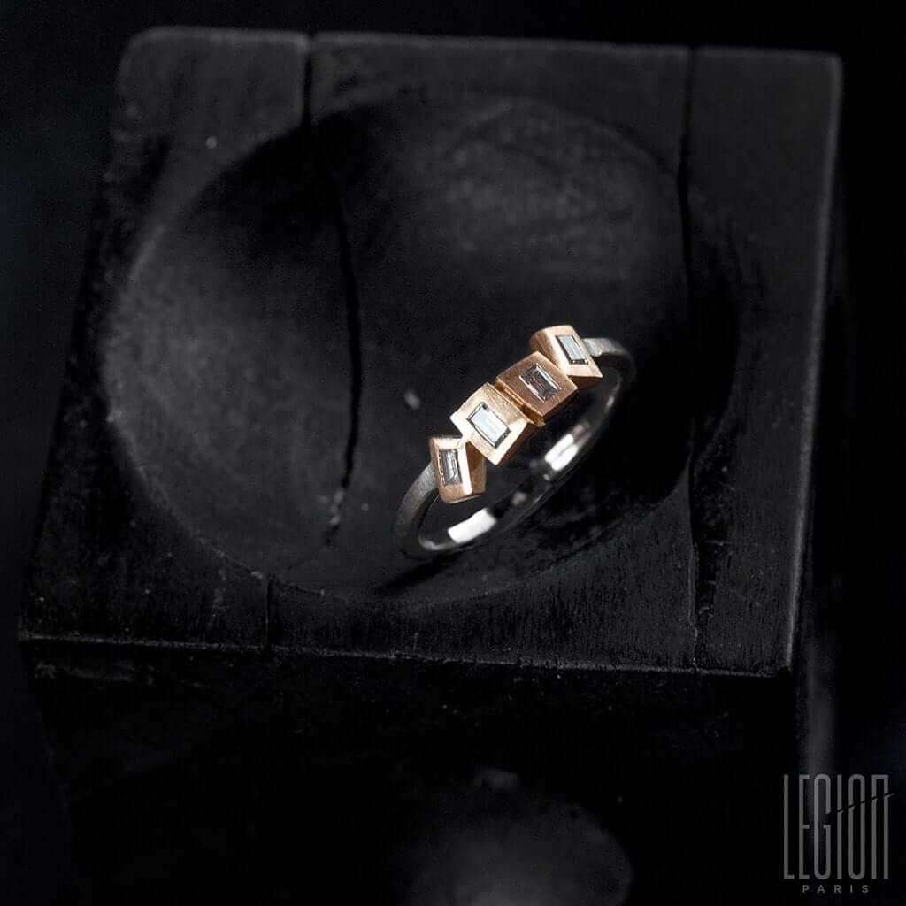 bague de côté avec des diamants sur le dessus et des chatons en or rouge et un corps de bague en or blanc