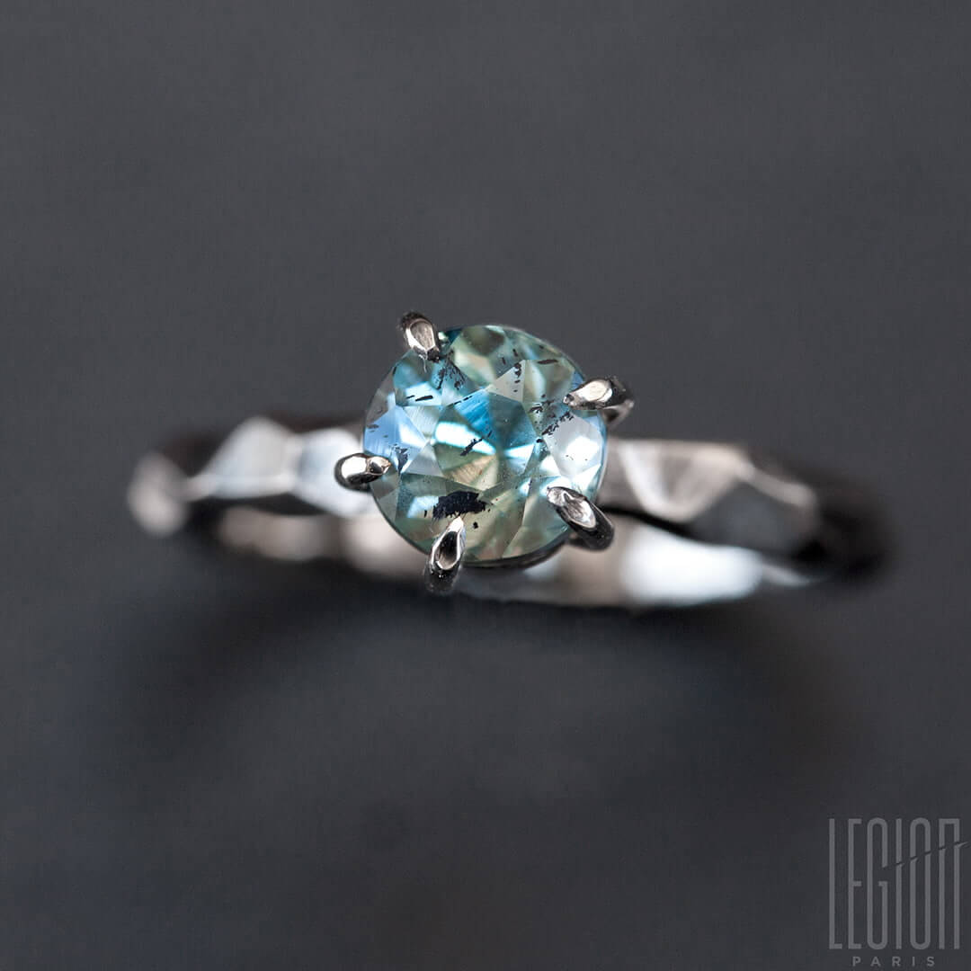 tres gros plan d'une bagutres gros plan d'une bague solitaire en or blanc texturée avec une pierre aigue marine bleue