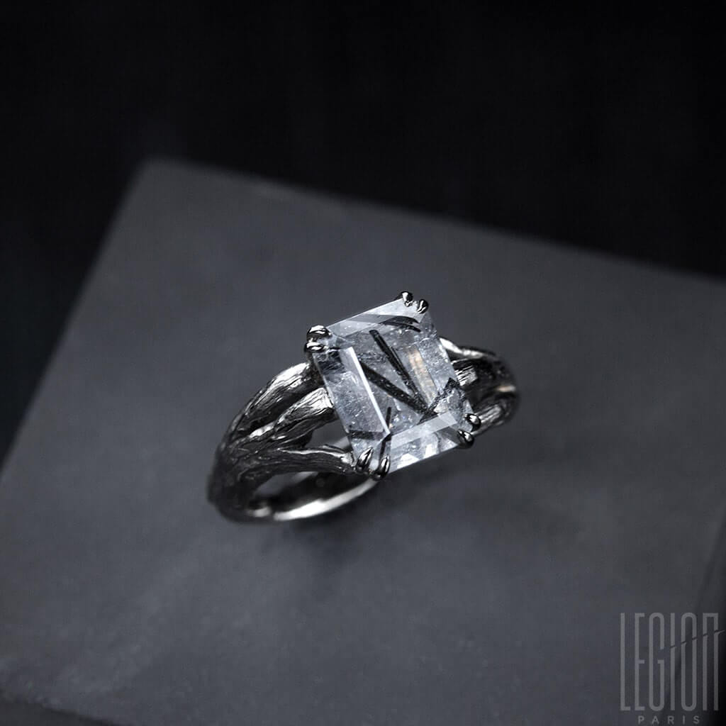 vue de côté d'une bague de fiançailles Legion Paris en or blanc avec une pierre centrale 