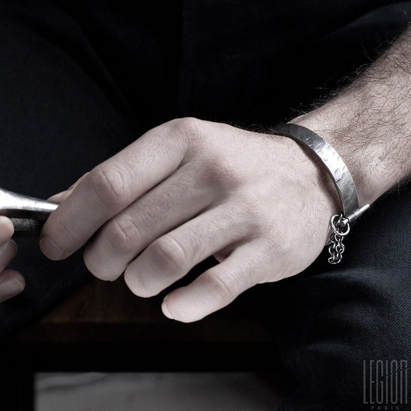 main d'homme portant un bracelet rigide en argent noir 