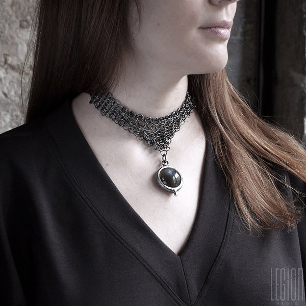 femme portant un collier en côte de maille en argent noir avec un gros pendentif en pierre de lune noire 