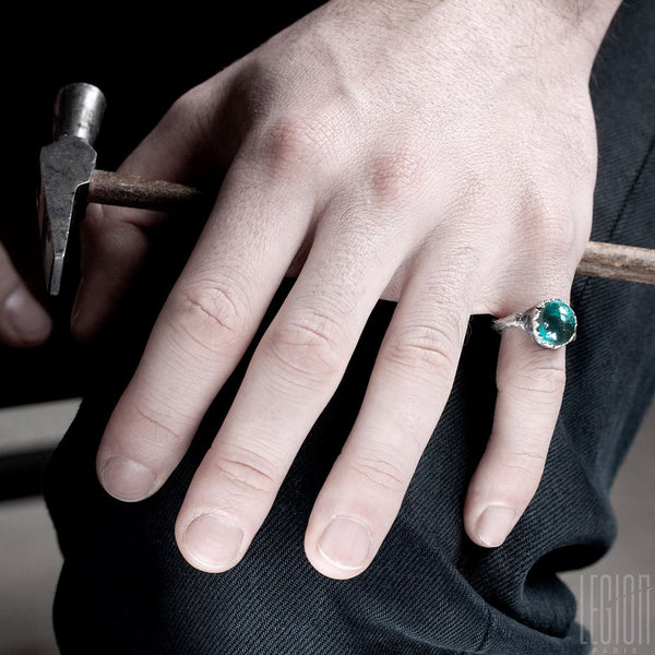 main d'homme portant une bague en argent avec une tourmaline bleue