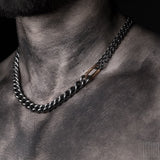 cou d'homme torse nu qui porte un collier en argent noir fait a partir de chaine gourmette avec un maillon en or rouge martelé