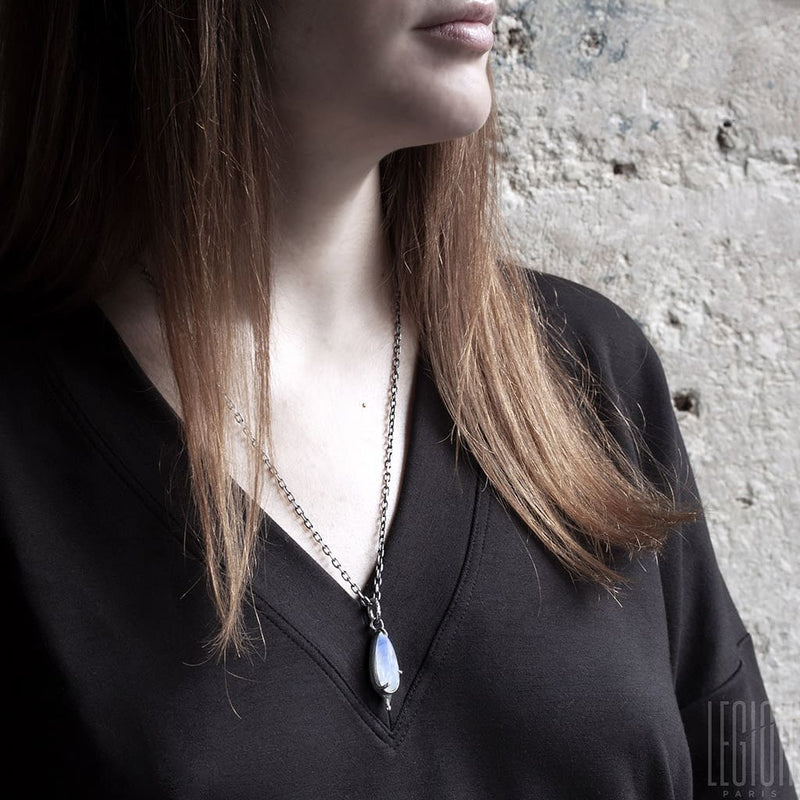 redheaded woman wearing a pendant with a white stone from a
