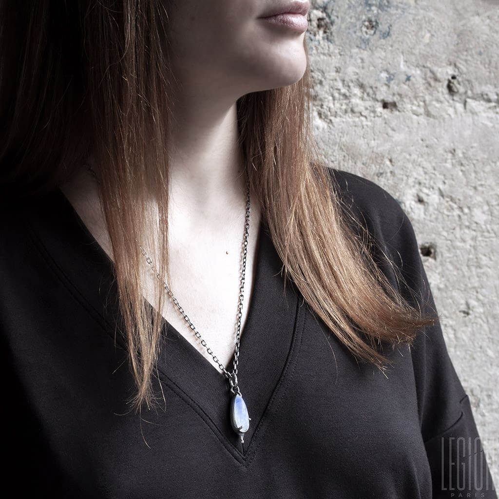 femme rousse portant un pendentif avec une pierre blanche pierre de une